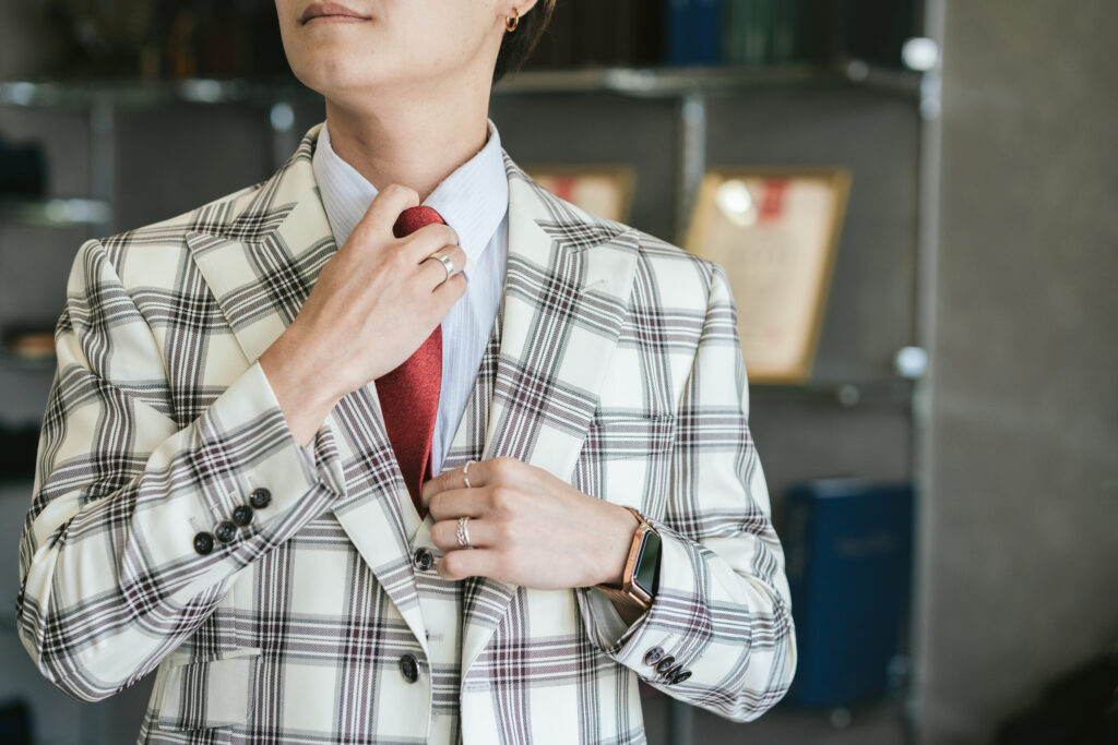 仕上がったジャケットを試着してネクタイを整える様子